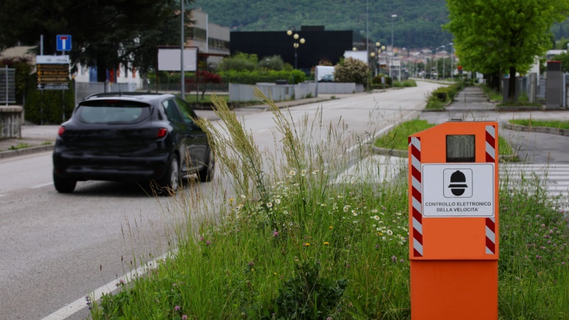 Autovelox sulla strada con auto nera che passa